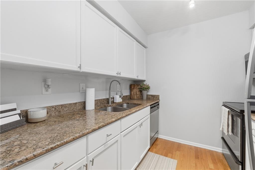 1150 Collier Road Northwest, Unit 6H Atlanta, GA 30318 - Photo 12 of 29 a kitchen with granite countertop a sink a stove and cabinets
