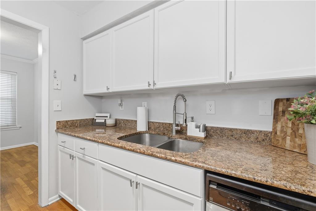 1150 Collier Road Northwest, Unit 6H Atlanta, GA 30318 - Photo 13 of 29 a kitchen with granite countertop white cabinets and a sink