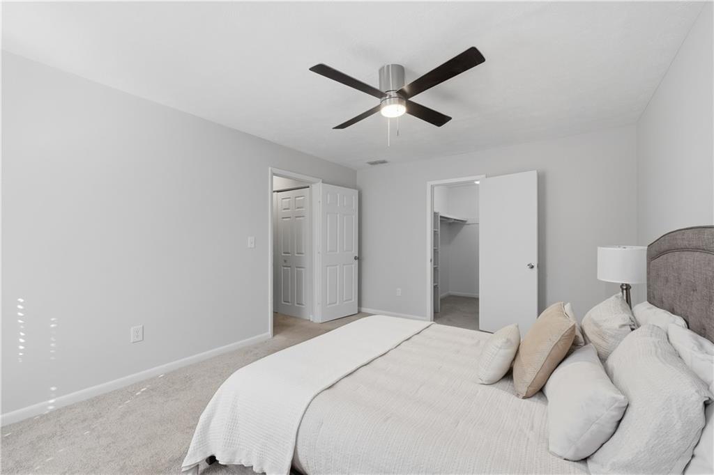 1150 Collier Road Northwest, Unit 6H Atlanta, GA 30318 - Photo 16 of 29 a bedroom with a large bed and a chandelier