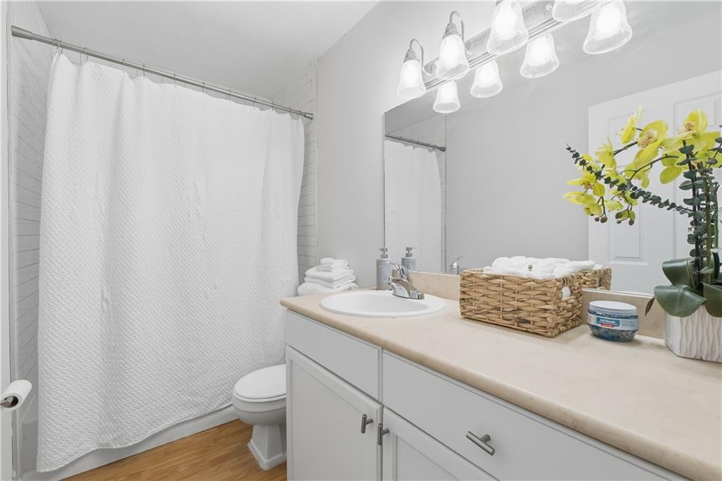 1150 Collier Road Northwest, Unit 6H Atlanta, GA 30318 - Photo 17 of 29 a bathroom with a sink a toilet and a mirror