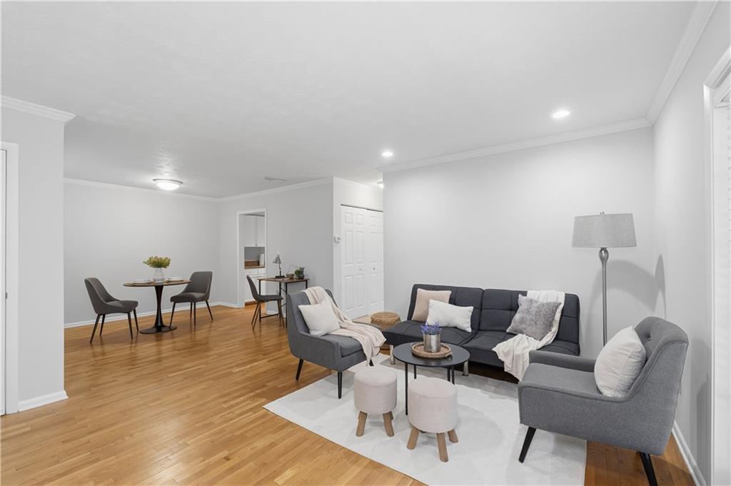 1150 Collier Road Northwest, Unit 6H Atlanta, GA 30318 - Photo 5 of 29 a living room with furniture a dining table and a potted plant