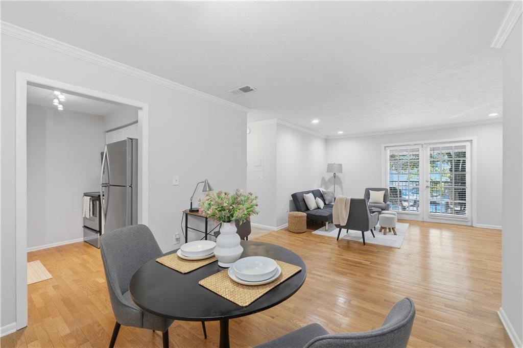 1150 Collier Road Northwest, Unit 6H Atlanta, GA 30318 - Photo 9 of 29 a view of a dining room with furniture and wooden floor