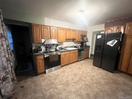 a kitchen with stainless steel appliances granite countertop a refrigerator a stove a sink and a microwave