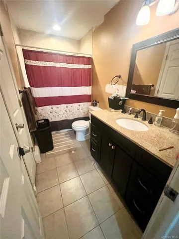 a bathroom with a sink vanity granite and toilet