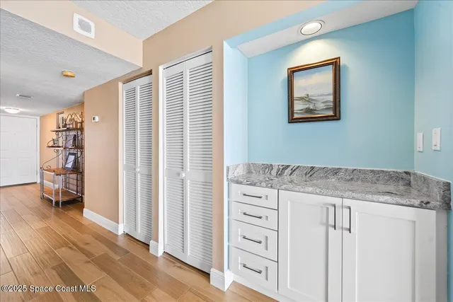 a hallway with cabinets and wooden floor