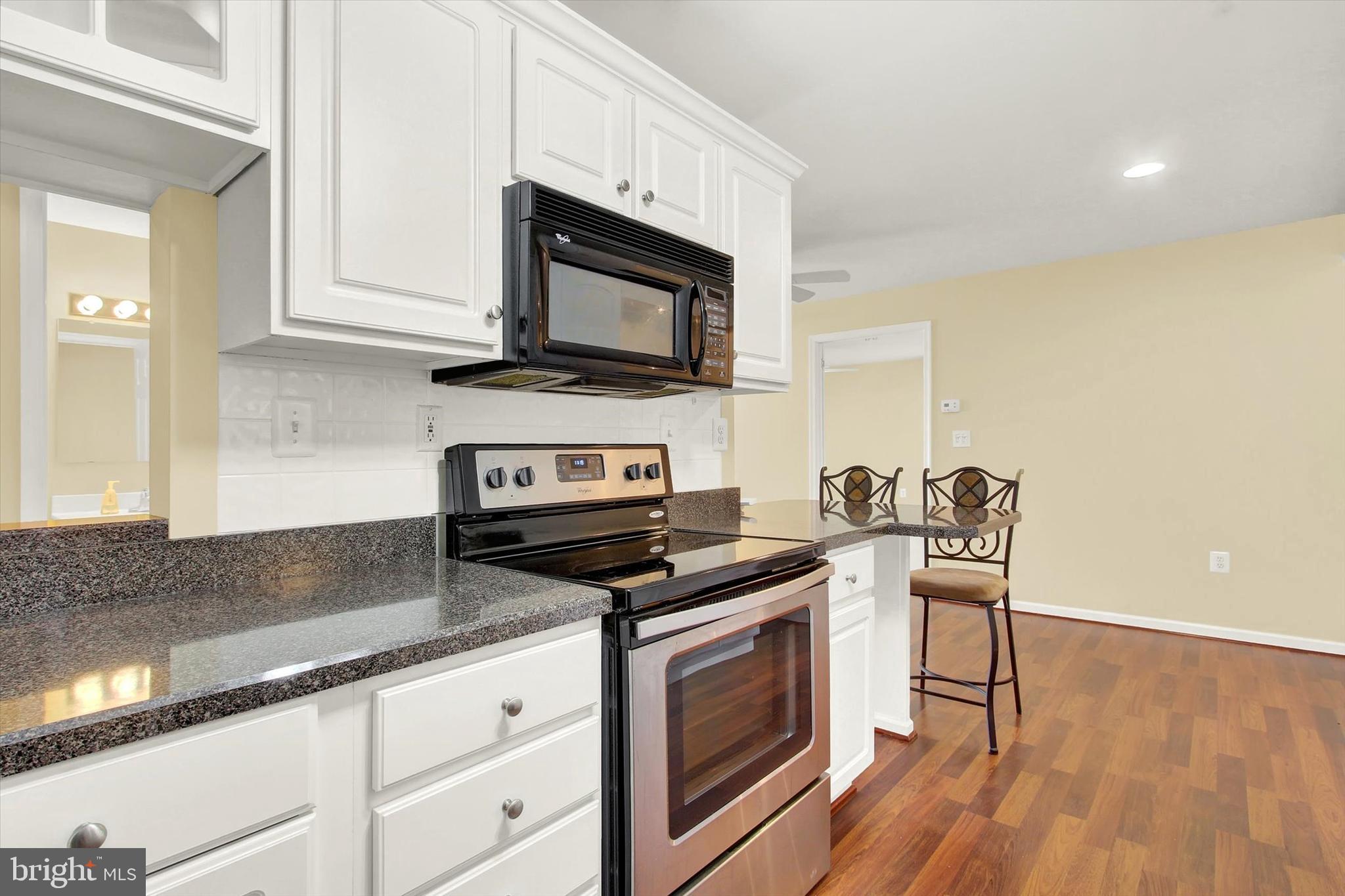 6500 Ridenour Way East, Unit 3C Sykesville, MD 21784 - Photo 15 of 22 a kitchen with stainless steel appliances granite countertop a stove a sink and a microwave