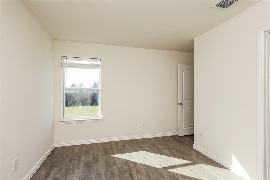 2712 William Street Mabank, TX 75147 - Photo 13 of 20 a view of an empty room with wooden floor and a window