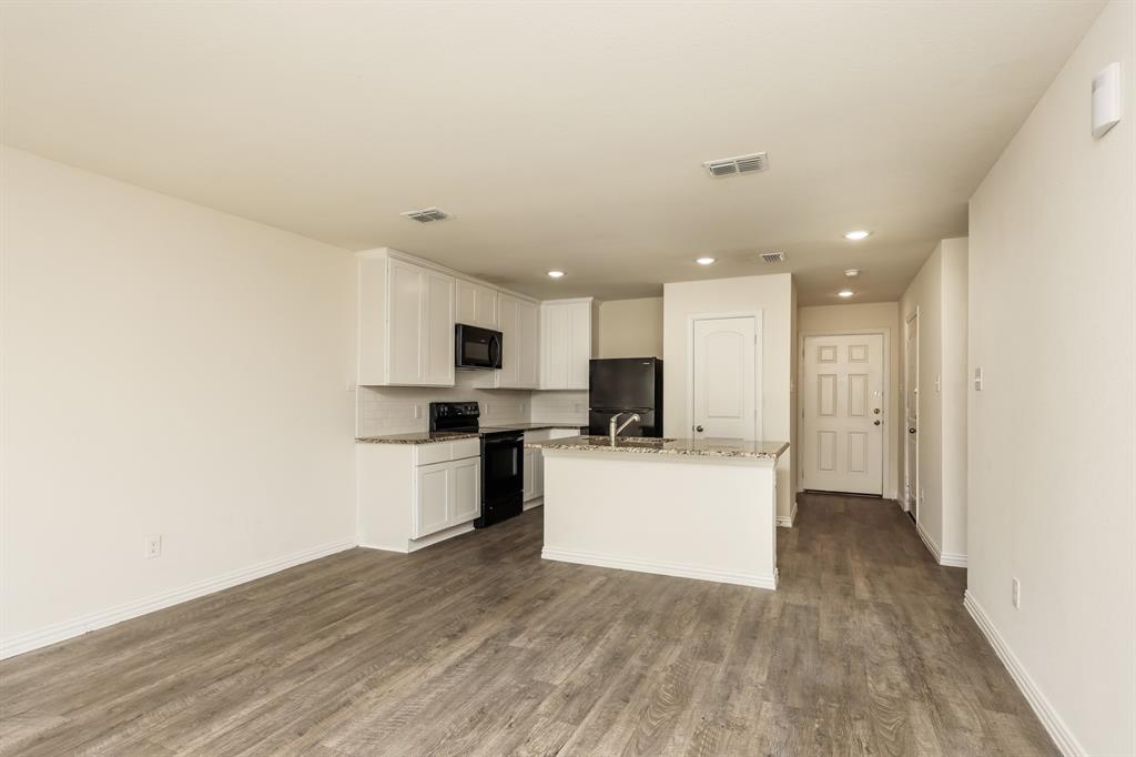 2712 William Street Mabank, TX 75147 - Photo 4 of 20 a view of kitchen with kitchen island a sink wooden floor and a stove