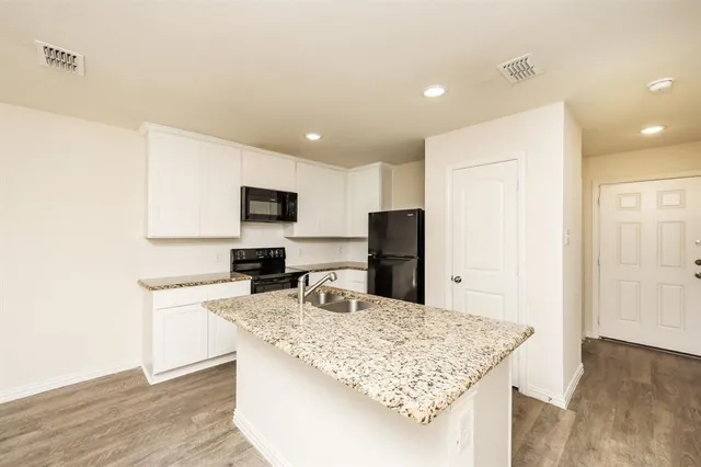 a kitchen with stainless steel appliances granite countertop a sink refrigerator and microwave