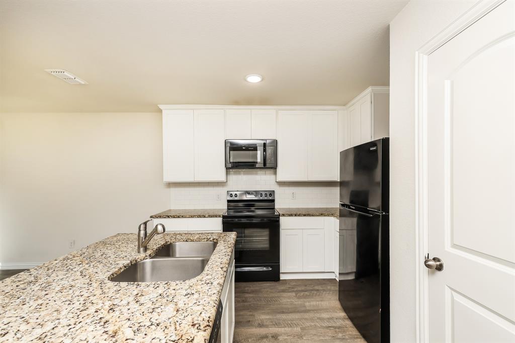 2712 William Street Mabank, TX 75147 - Photo 9 of 20 a kitchen with stainless steel appliances granite countertop a refrigerator sink and stove