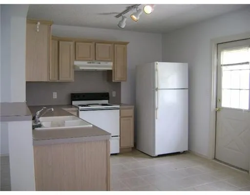 a kitchen with a sink a refrigerator and cabinets