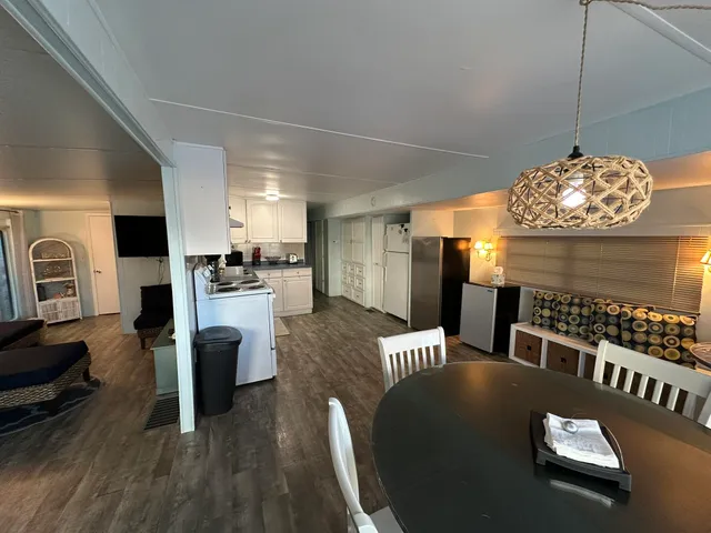 a kitchen with sink refrigerator dining table and chairs