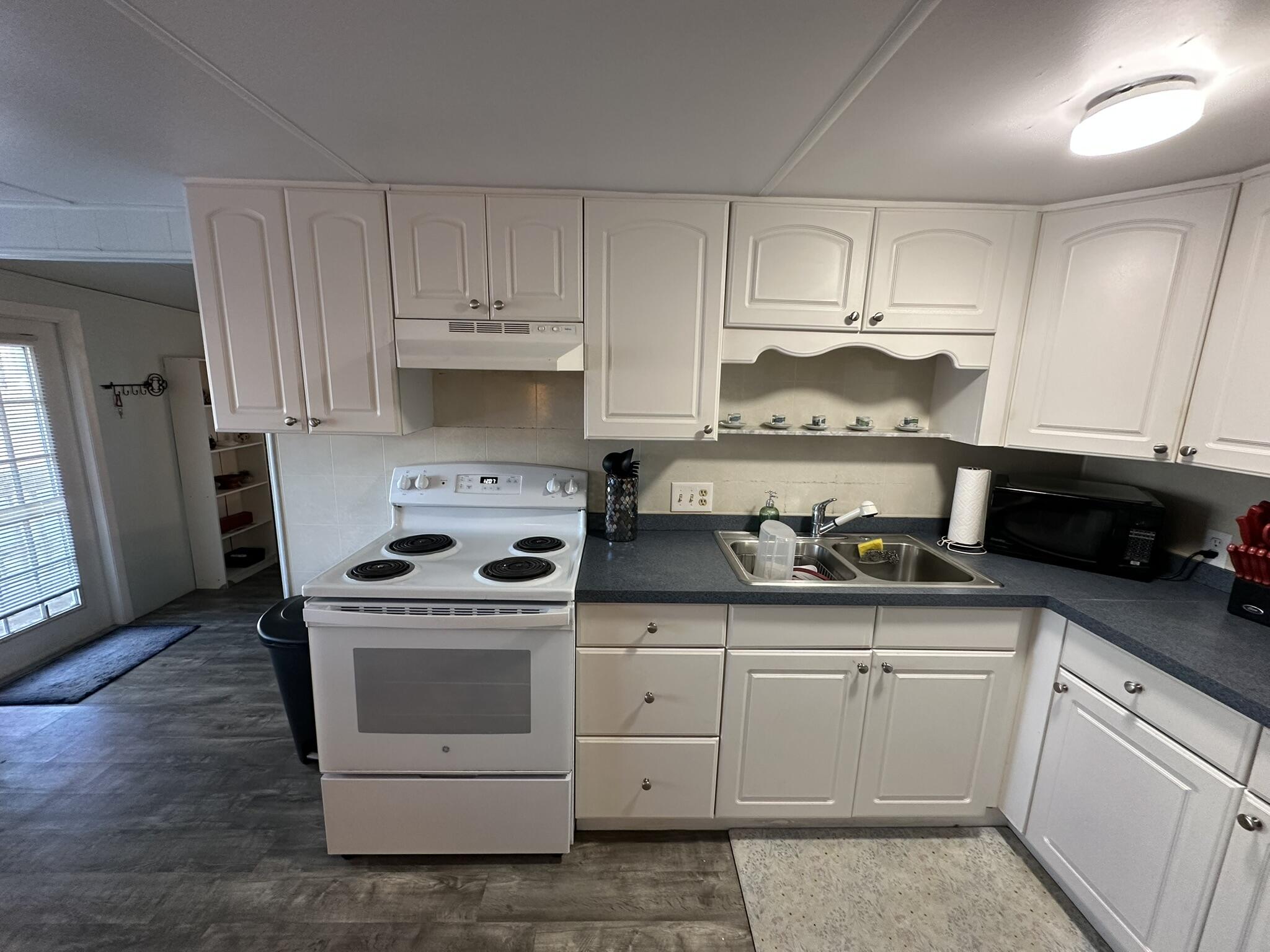 65821 Overseas Highway, Unit 310 Long Key, FL 33001 - Photo 13 of 32 a kitchen with white cabinets and appliances