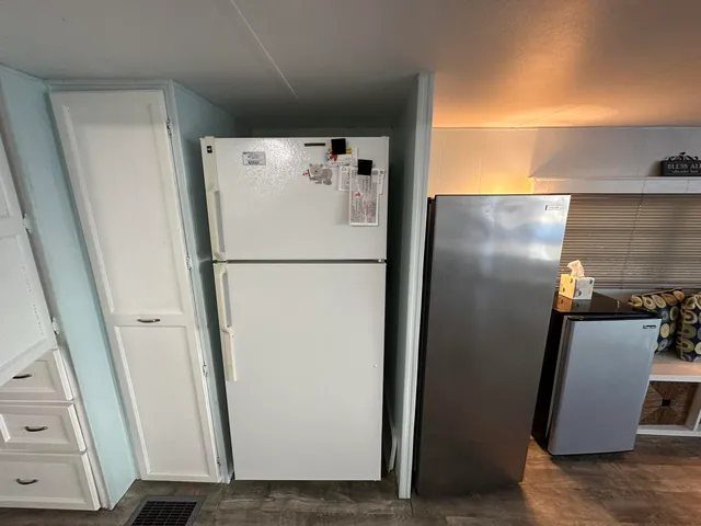 a white refrigerator freezer and a microwave in a shelf