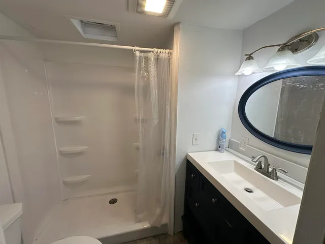 a bathroom with a sink a mirror and a shower