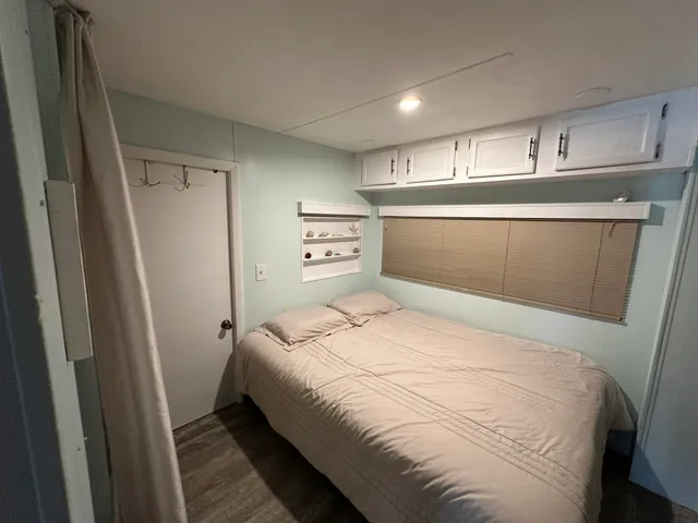 a bedroom with a bed and a refrigerator