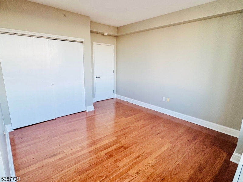 1806 One Spring Street, Unit 1806 New Brunswick, NJ 08901 - Photo 22 of 49 a view of an empty room with wooden floor and a shower