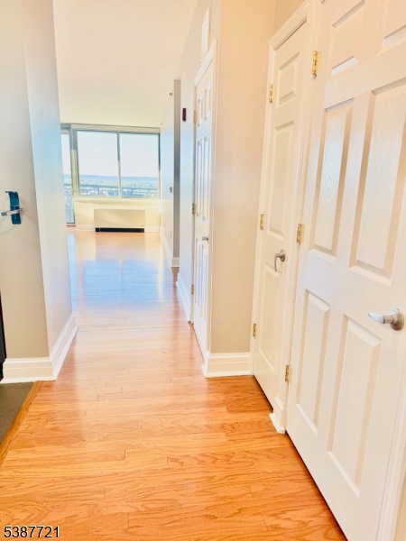 1806 One Spring Street, Unit 1806 New Brunswick, NJ 08901 - Photo 3 of 49 a view of a hallway with wooden floor and cabinet