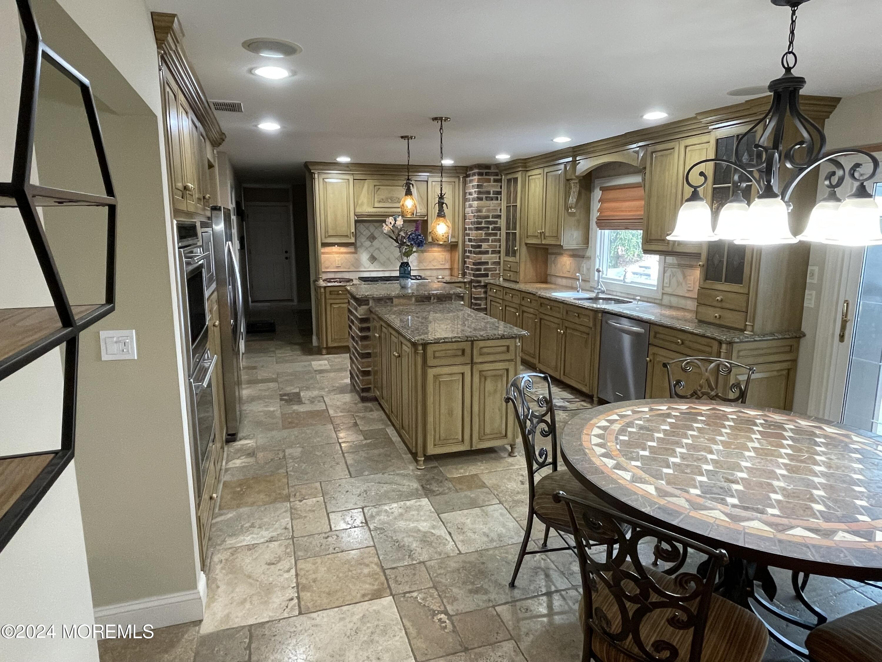 1 Longstreet Road Manalapan, NJ 07726 - Photo 8 of 76 a kitchen with a table chairs refrigerator and microwave