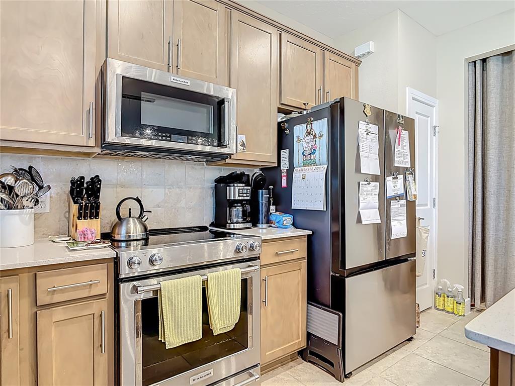 2248 Canopy Terrace Boulevard DeLand, FL 32724 - Photo 13 of 49 a kitchen with stainless steel appliances granite countertop a refrigerator sink and microwave