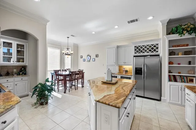 a kitchen with granite countertop a table and chairs