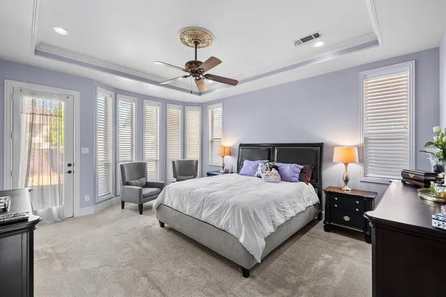 a bedroom with a large bed and a chandelier