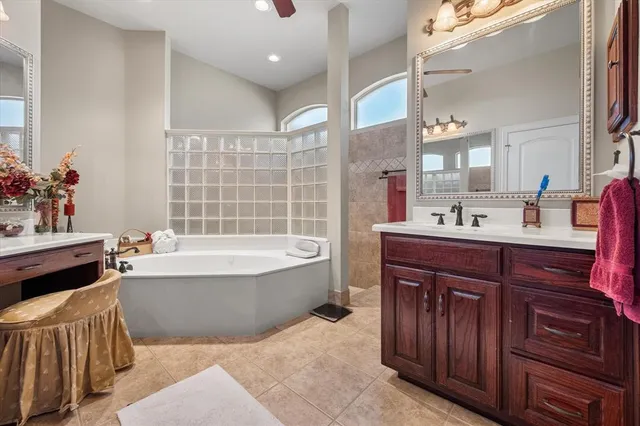 a spacious bathroom with a tub sink and mirror
