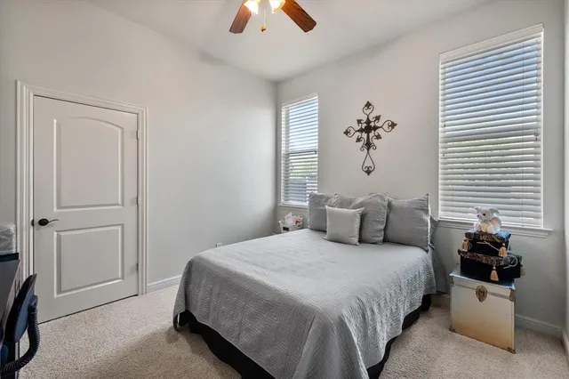 a bedroom with a bed and a chandelier fan