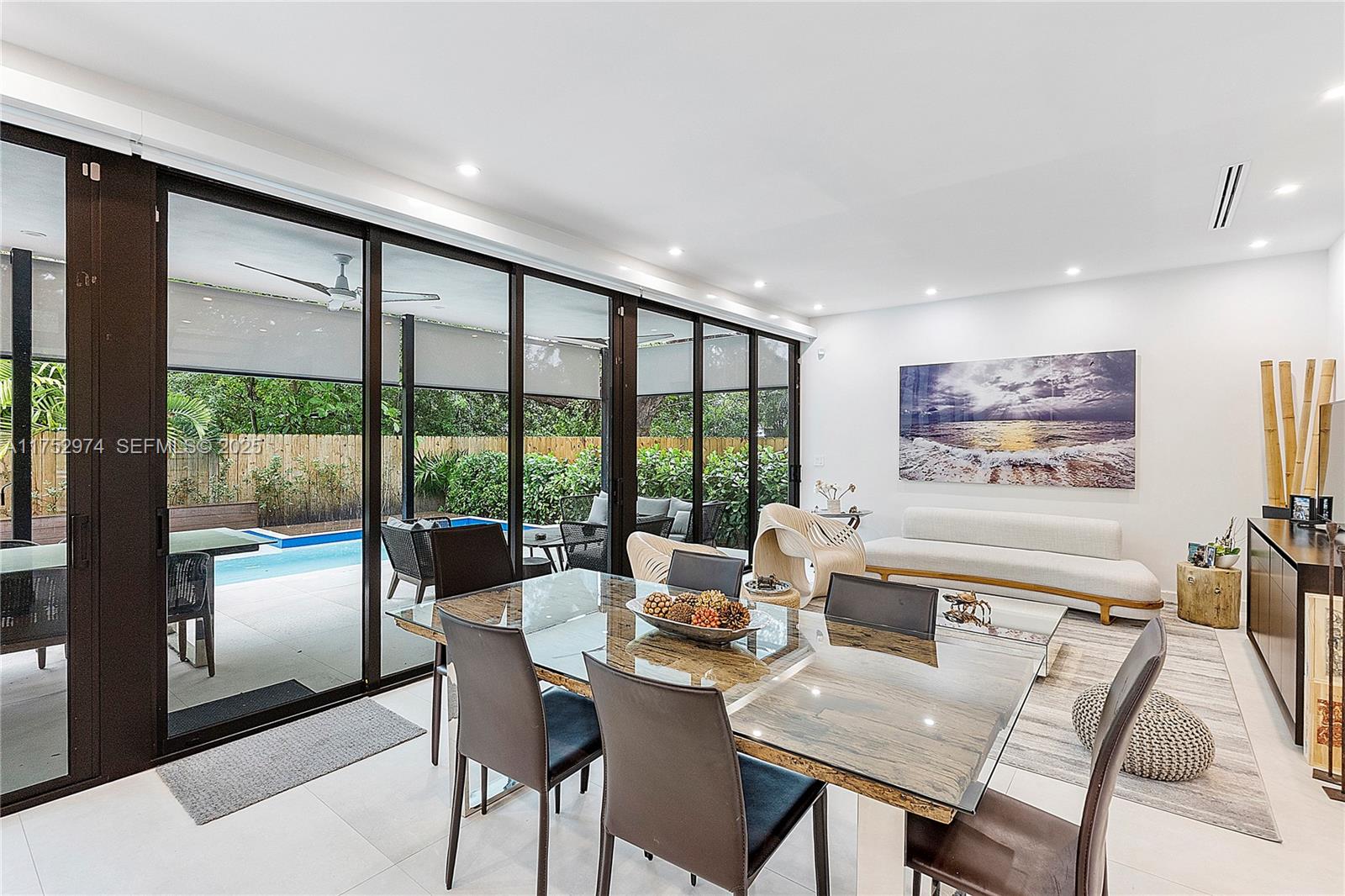 3664 Oak Avenue Miami, FL 33133 - Photo 12 of 39 a dining room with furniture large windows and a chandelier