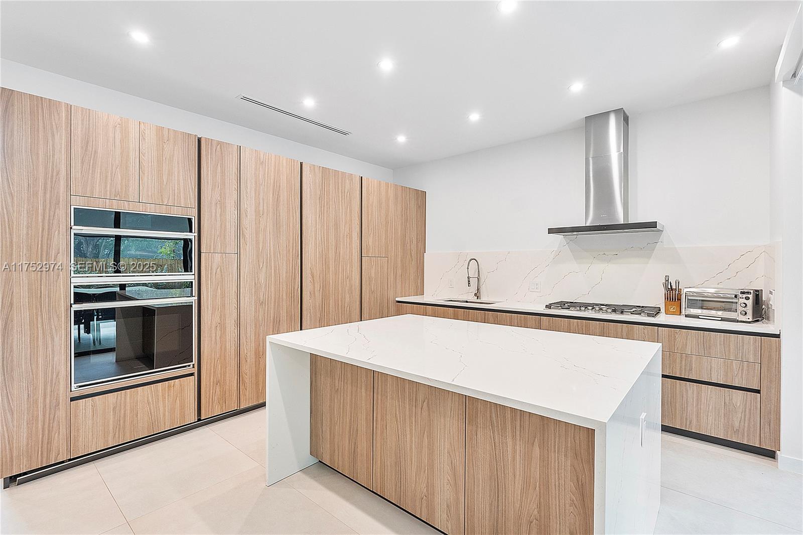 3664 Oak Avenue Miami, FL 33133 - Photo 17 of 39 a kitchen with stainless steel appliances a stove top oven and a refrigerator
