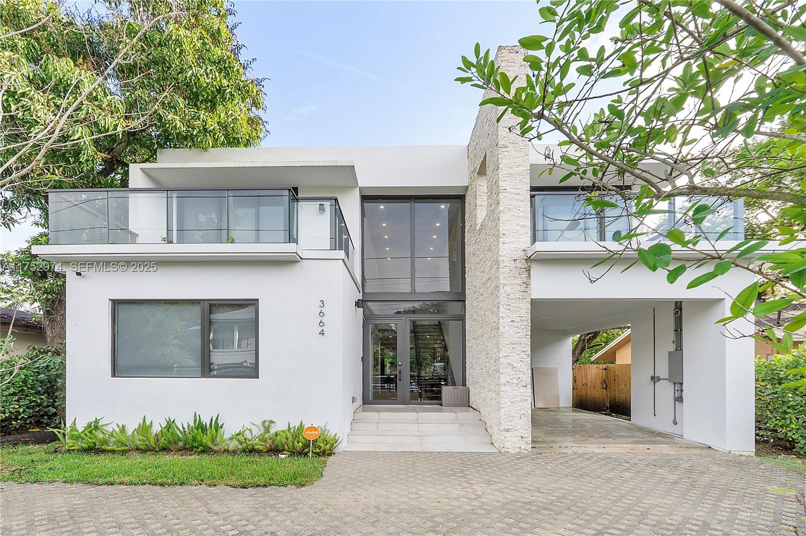 3664 Oak Avenue Miami, FL 33133 - Photo 2 of 39 a front view of a house with a yard and garage