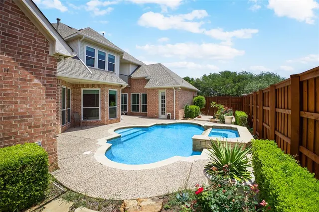 a view of a house with pool fire pit and chairs in patio