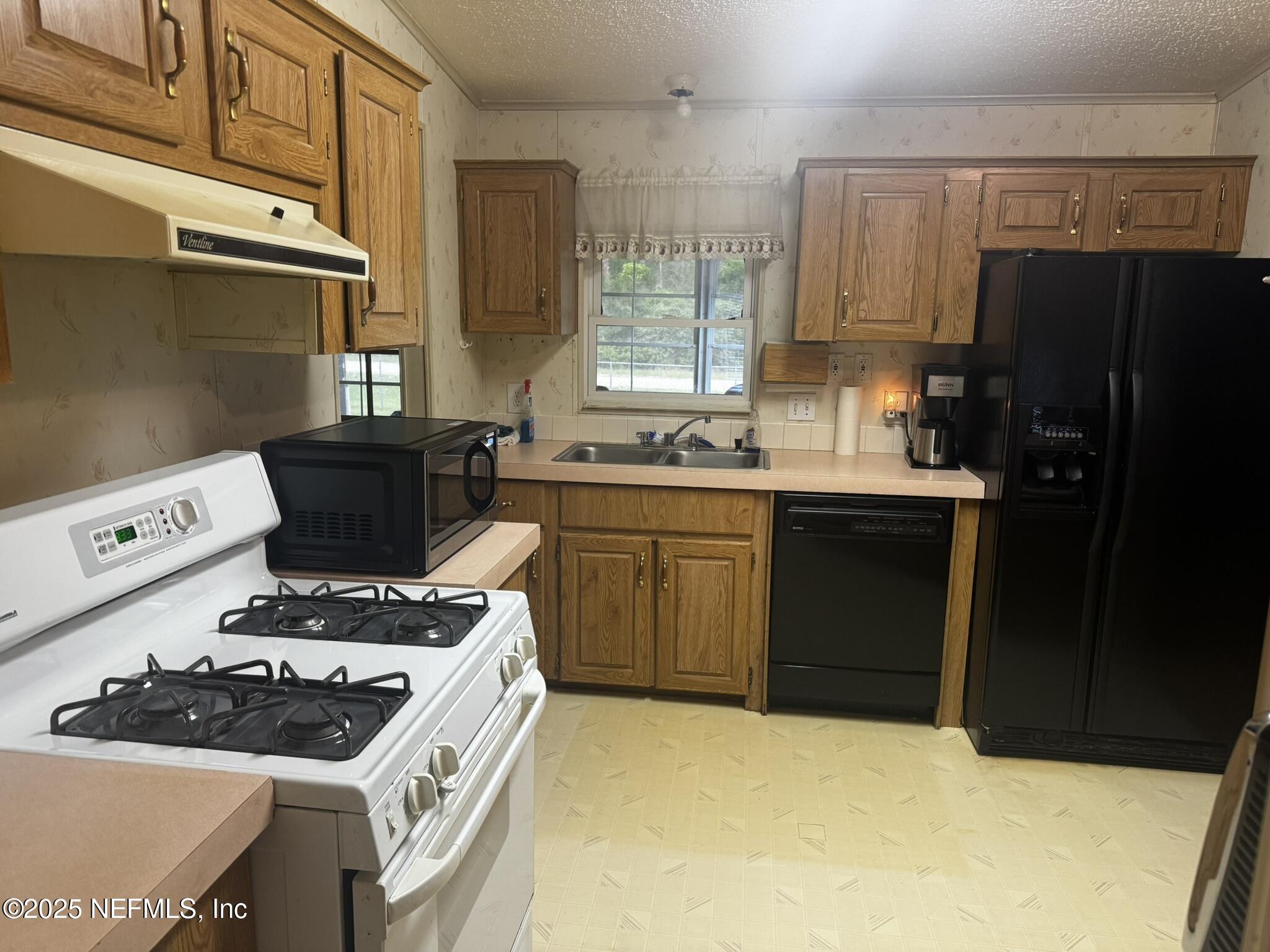 115 Edgemere Drive Georgetown, FL 32139 - Photo 14 of 24 a kitchen with a sink a stove and refrigerator