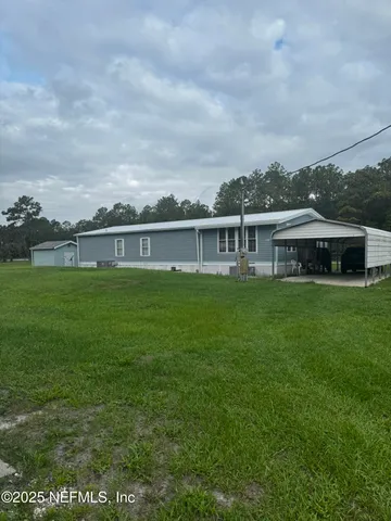 a view of a house with a big yard and potted plants
