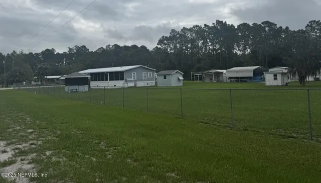 a view of a house with a big yard and a large tree