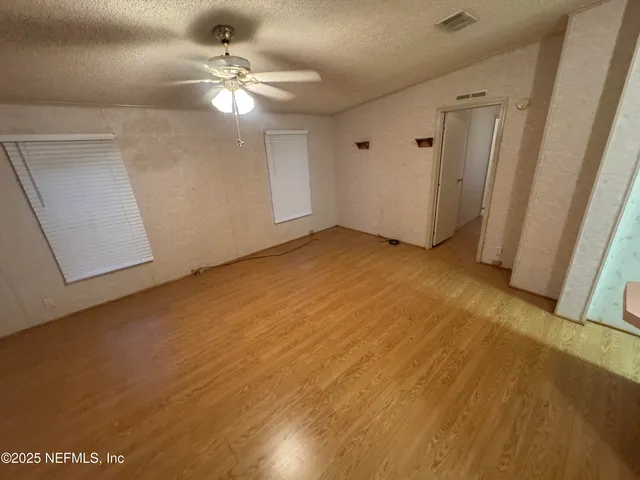a view of empty room with wooden floor