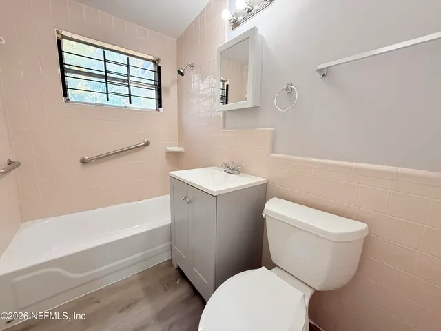 a white toilet sitting next to a bath tub