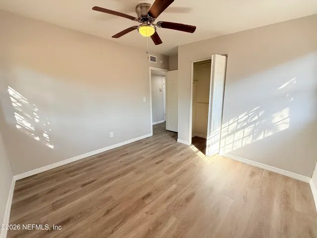 a view of empty room with wooden floor
