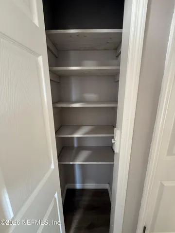 a view of walk in closet with empty racks