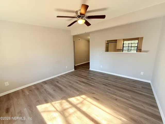 a view of a big room with wooden floor and a ceiling fan