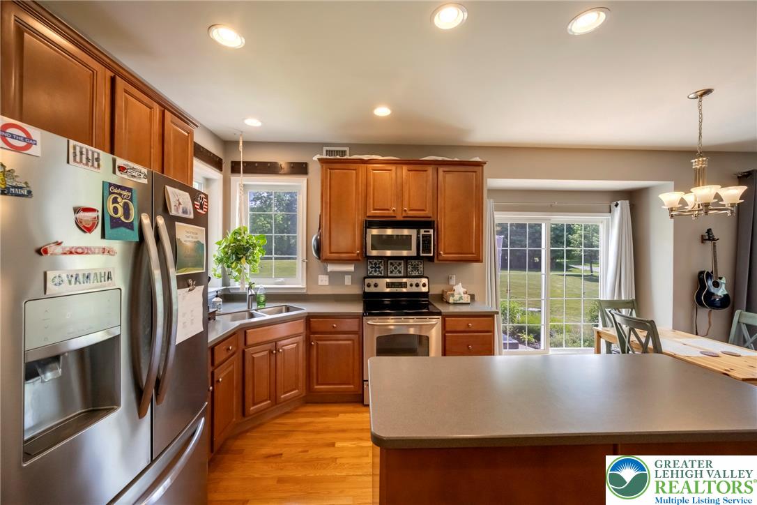 204 Bushkill Ridge Road Wind Gap, PA 18091 - Photo 12 of 48 A well-appointed kitchen features stainless steel appliances, abundant cabinetry, and a sliding glass door leading to a verdant outdoor space.