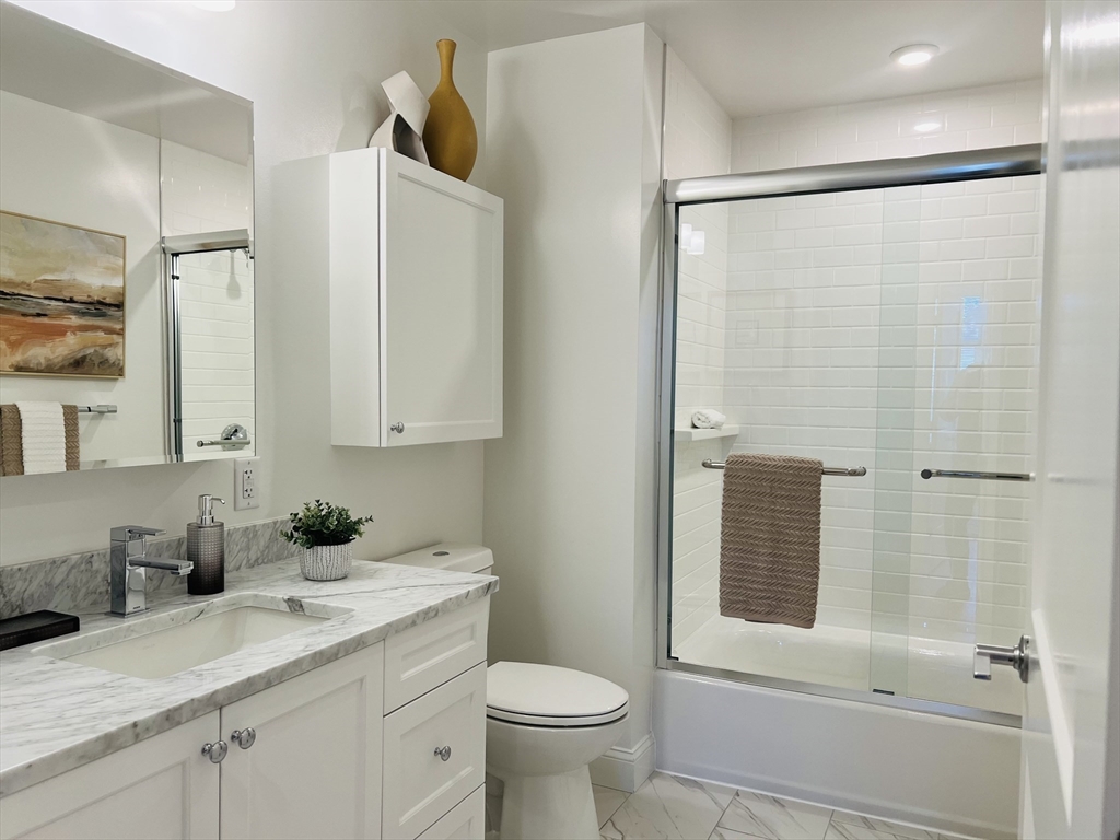 201 Sherman Road, Unit 309 Brookline, MA 02467 - Photo 22 of 25 a bathroom with a granite countertop sink toilet and shower