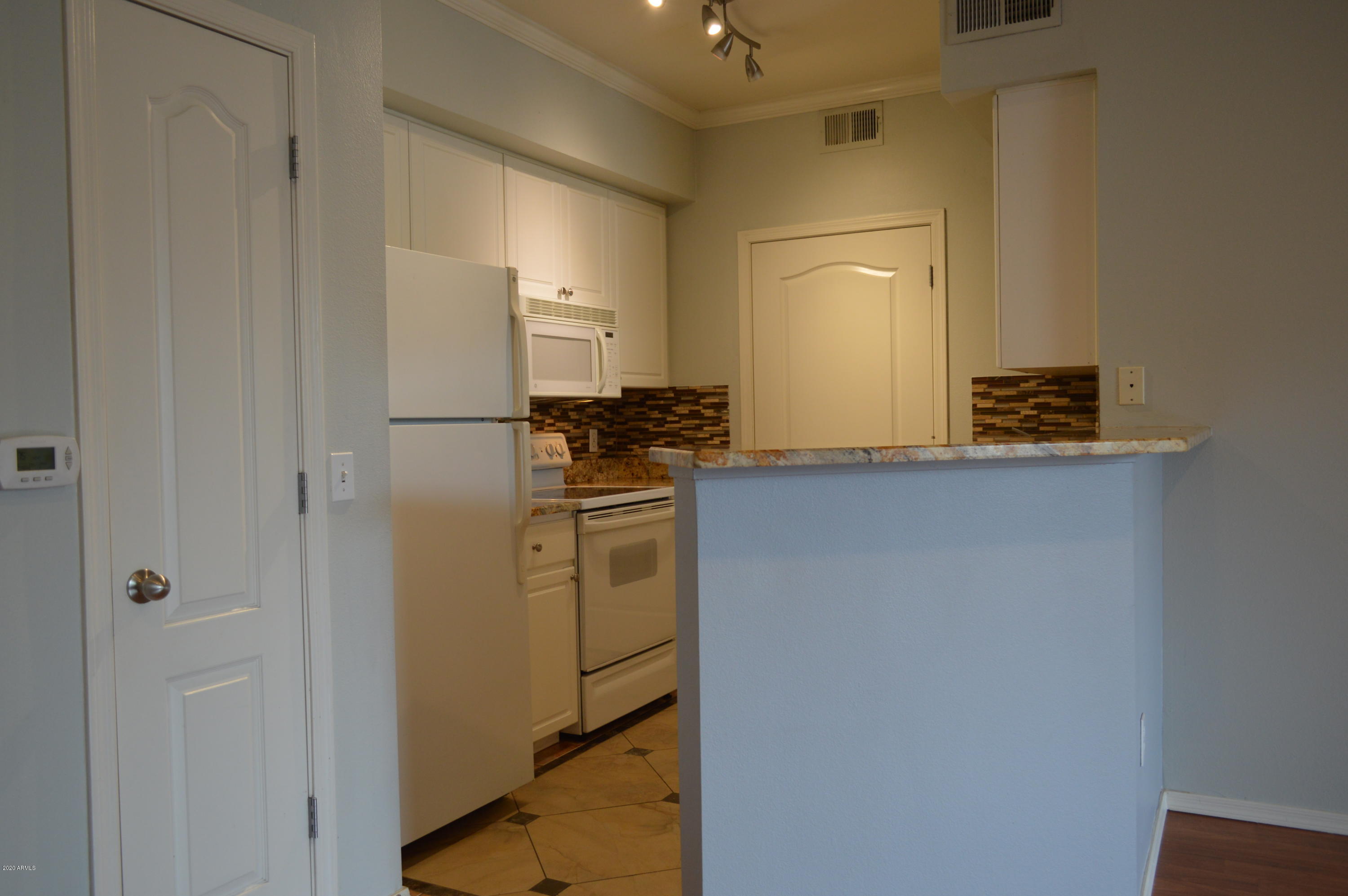 1701 East Colter Street, Unit 308 Phoenix, AZ 85016 - Photo 4 of 50 a kitchen with a refrigerator and cabinets