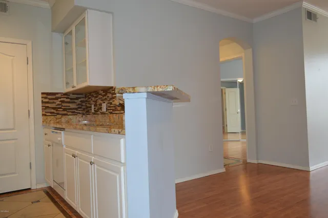 wooden floor with cabinet in front of door