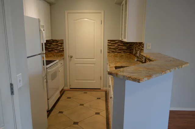 a bathroom with a granite countertop sink and washing machine