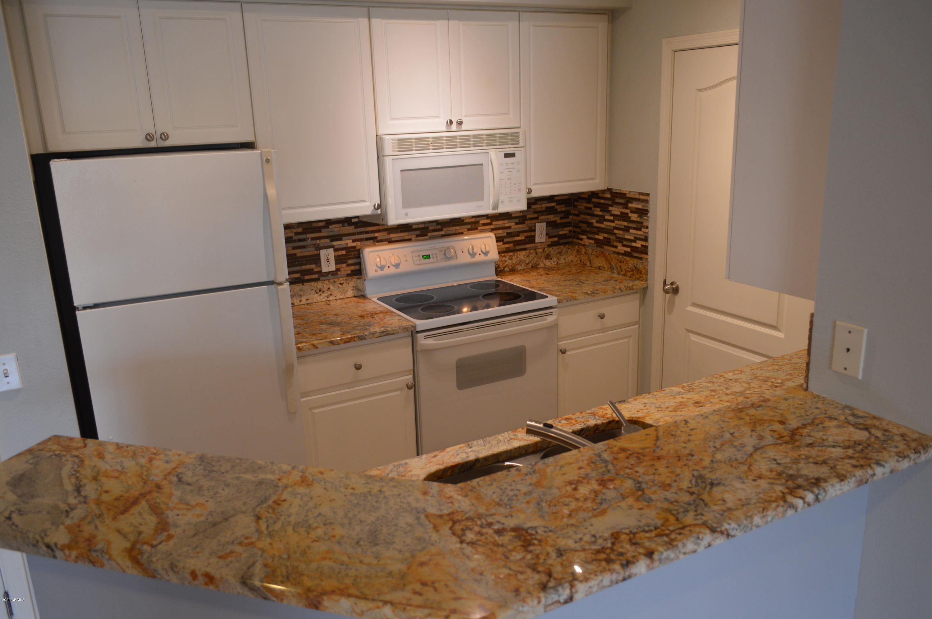 1701 East Colter Street, Unit 308 Phoenix, AZ 85016 - Photo 9 of 50 a kitchen with a stove and a refrigerator