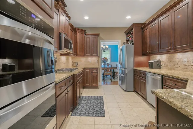 a kitchen with stainless steel appliances granite countertop a stove a sink and a microwave