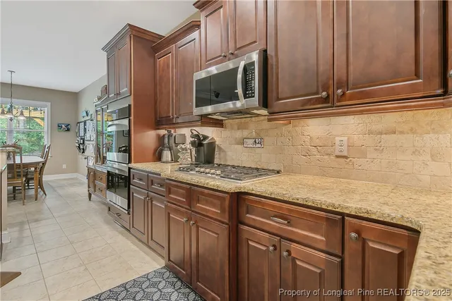a kitchen with stainless steel appliances granite countertop a stove a sink and a microwave