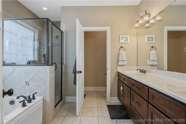 a spacious bathroom with a double vanity sink a mirror and a bathtub