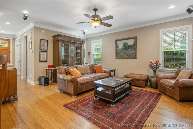 a living room with furniture a flat screen tv and a large window